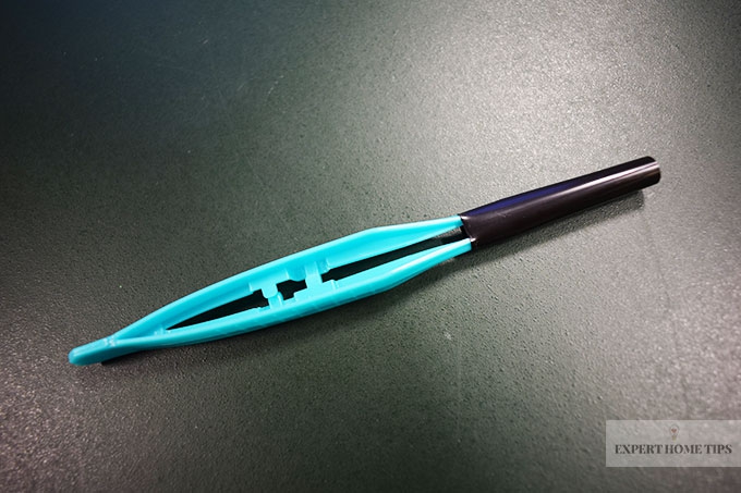 Blue tweezers in a black straw