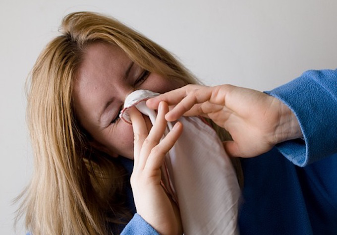 Woman with a cold blowing nose