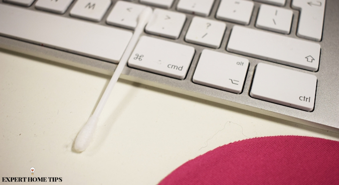 cleaning keyboard with a cotton bud